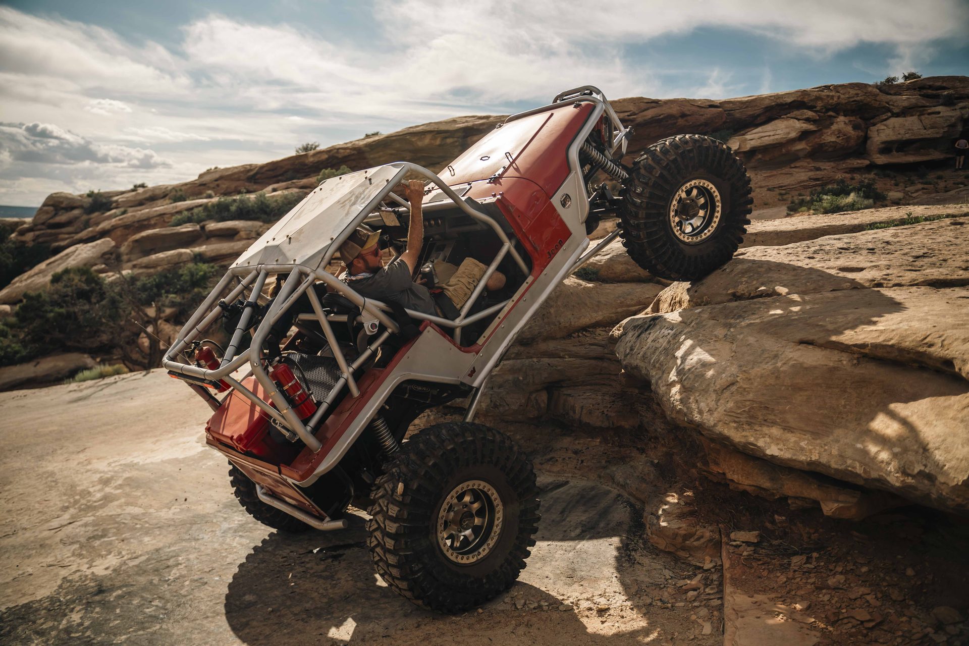 Caged Jeep climbing a sandstone ledge